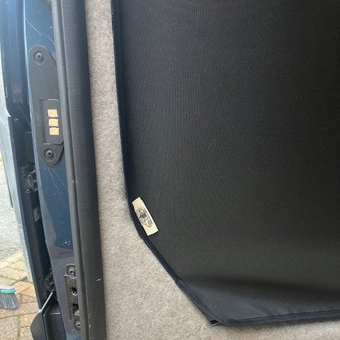 Lower corner of the Ford Transit Custom KabinKurtain with brand label, against the side panel