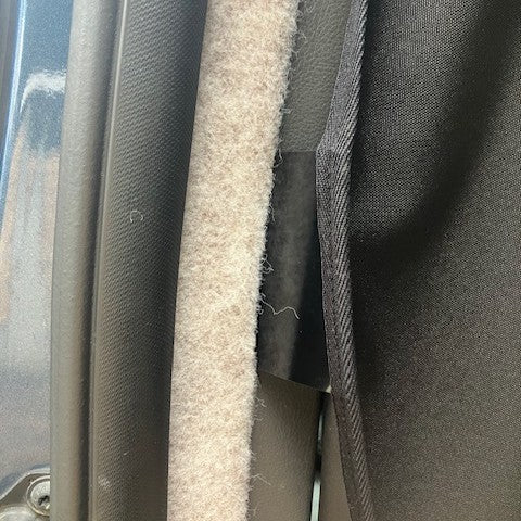 Close-up of the KabinKurtain edge tucked into the Ford Transit Custom pillar trim
